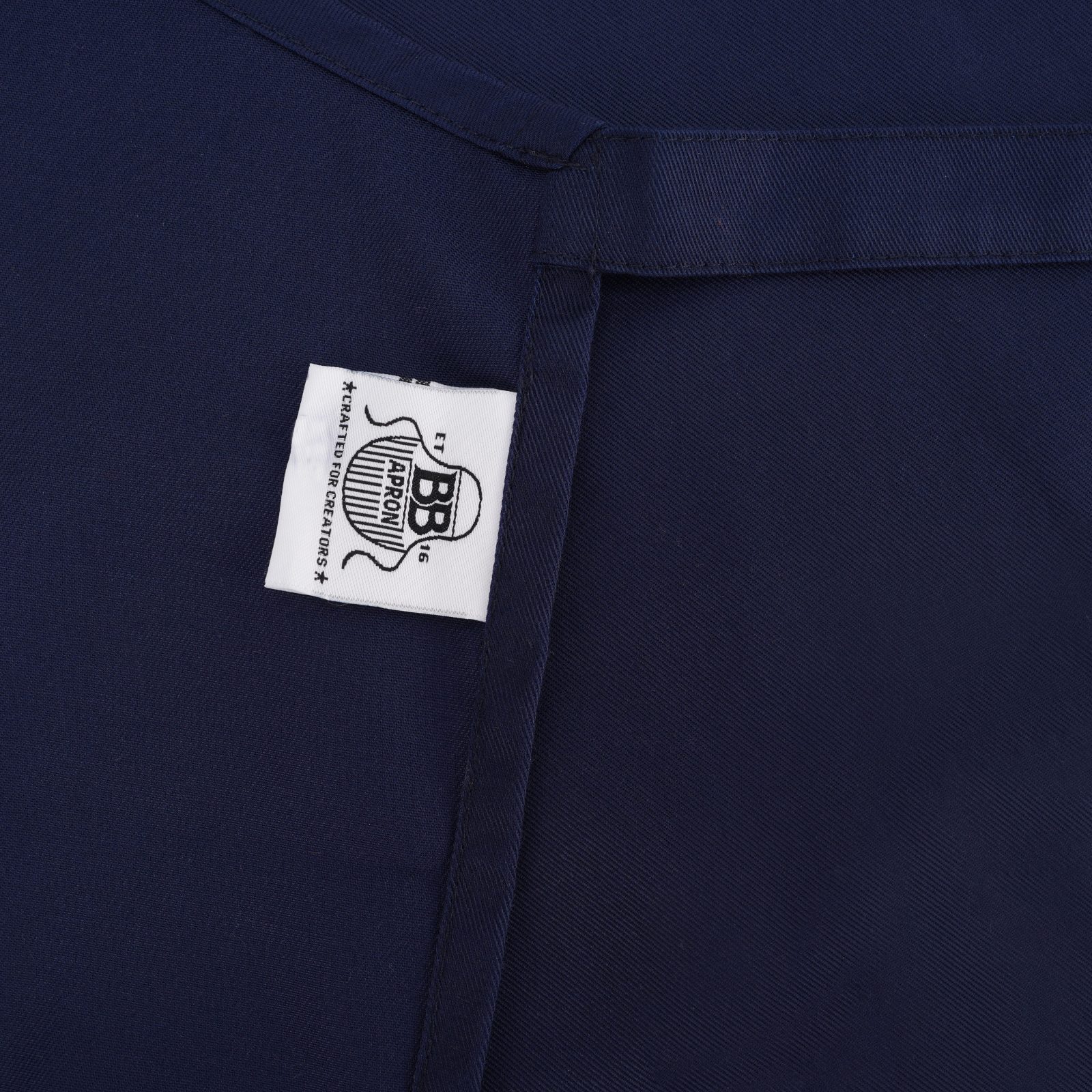 Close-up of the weave and woven label on a BB Apron twill fabric
